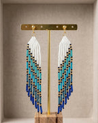 Boucles d'oreilles ailes longues franges perles de verre dégradé blanc, turquoise et bleu, détail acier inoxydable doré - Terre à Perles